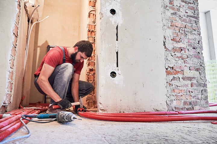 man installing heating system in apartment