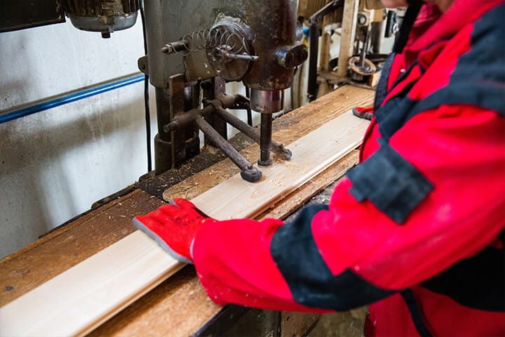 construction worker in red workwear working with a wooden structure