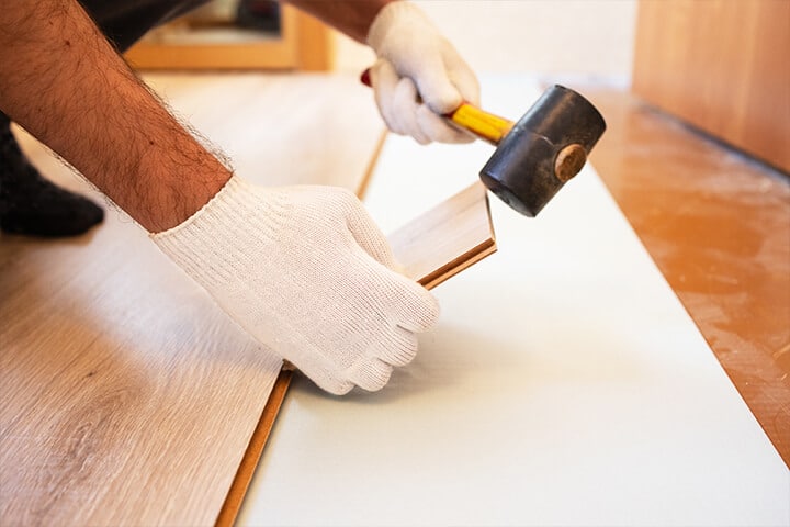 construction worker laying down floor tiles